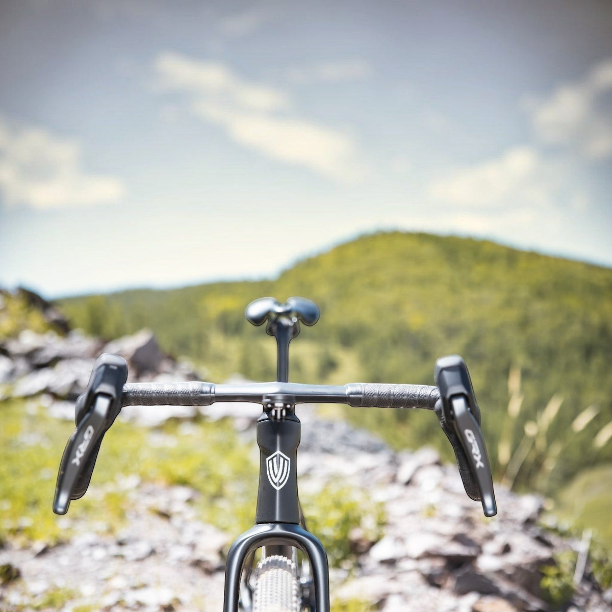 NorVelo G5 Gravel bike cockpit view with integrated handlebars and GRX shifters on a mountain trail background