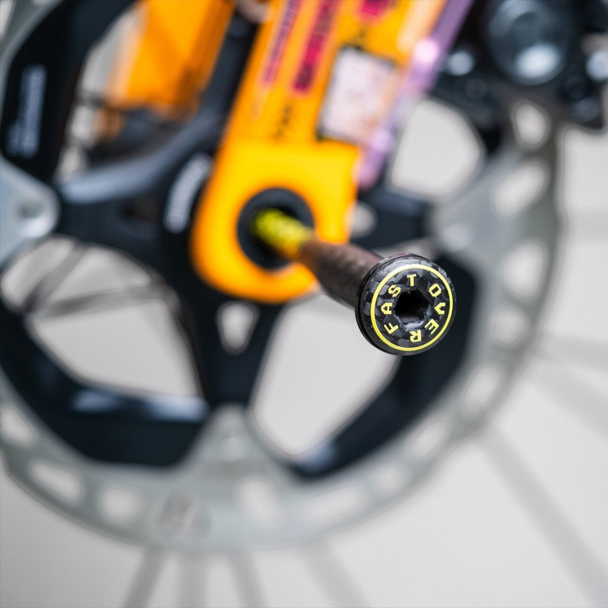 NorVelo OVERFAST ultralight carbon thru axle with titanium insert and yellow branding on a bicycle fork