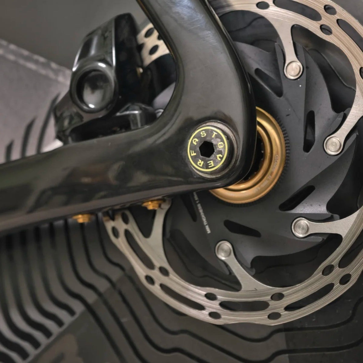 NorVelo OVERFAST ultralight carbon thru axle installed on a bicycle frame with a disc brake rotor