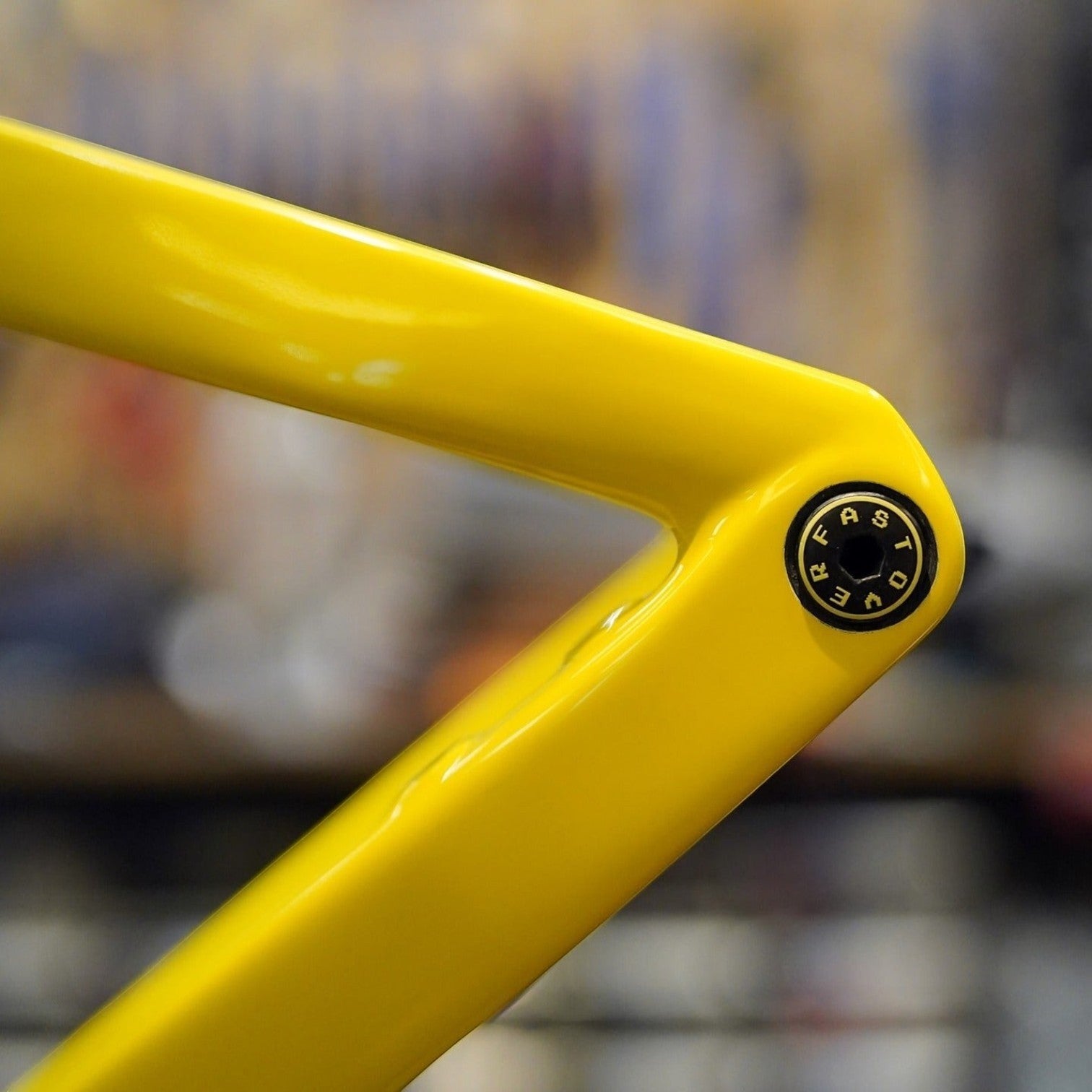 NorVelo OVERFAST ultralight thru axle installed on a bright yellow bicycle frame with a black branded end cap
