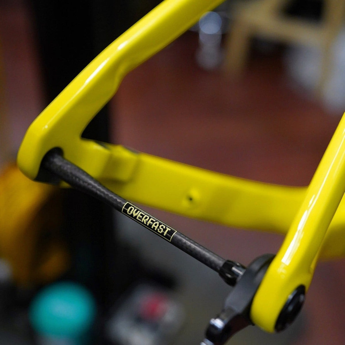 NorVelo OVERFAST ultralight carbon thru axle installed on a bright yellow bicycle frame for high-performance cycling.