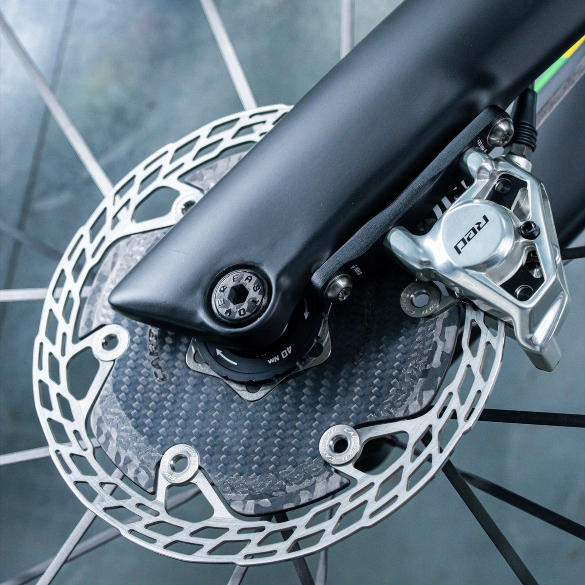 NorVelo OVERFAST ultralight thru axle installed on a bicycle fork with a carbon fiber disc brake rotor
